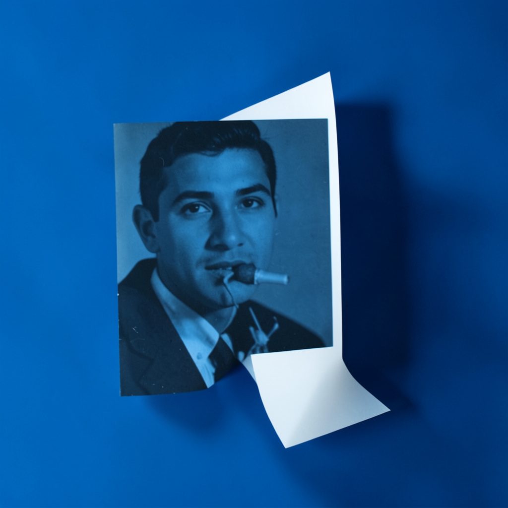 Hard duotone photograph of a blank open envelope in deep navy and soft cream, evoking a quiet, personal message.